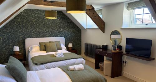 a attic bedroom with two beds and a television at The Carpenters Tavern in Dundry