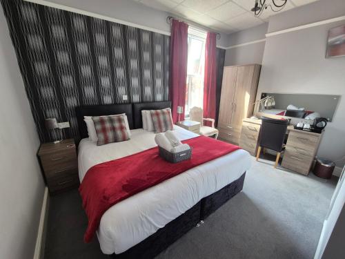 a bedroom with a large bed with a red blanket at The Braemar Southport in Southport