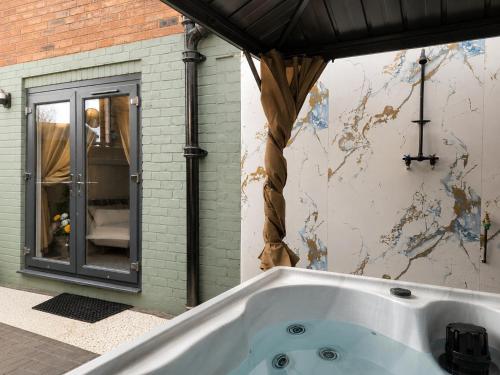 a bath tub in a room with a wall at Chester Charm - Spacious 3 Bedroom House in Chester
