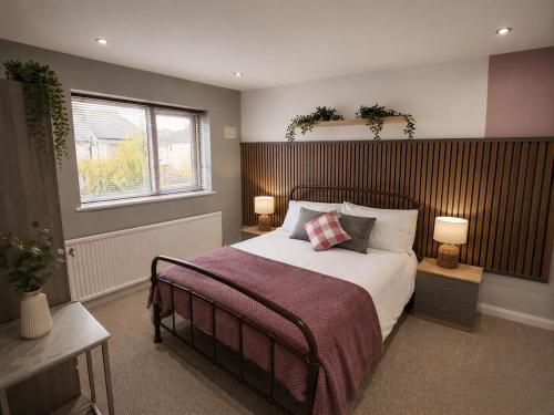 a bedroom with a bed and two lamps and a window at Chester Charm - Spacious 3 Bedroom House in Chester