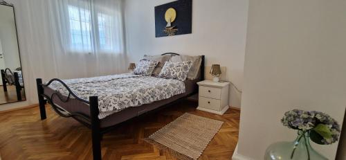 a bedroom with a bed and a vase of flowers at Apartment Sanjug in Šilo
