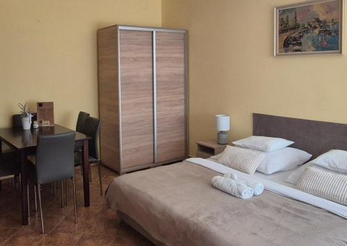 a bedroom with a bed and a desk and a table with a tableablish at Bazsarózsa Apartmanok Csopak in Csopak