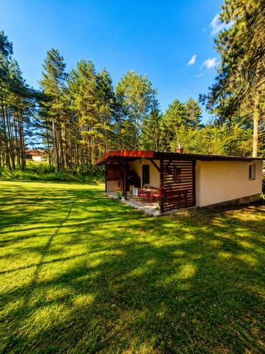 a small cabin in the middle of a grass field at Vikendica Stari Grad in Divčibare