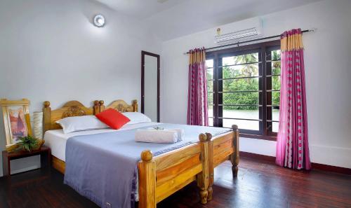 1 dormitorio con cama y ventana grande en Sreekrishna Houseboat - VACCINATED STAFF, en Kumarakom