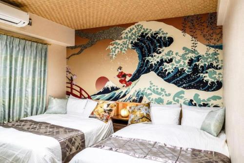two beds in a room with a painting on the wall at HOTEL StayLuck MARUGAME - 無料駐車場 in Marugame