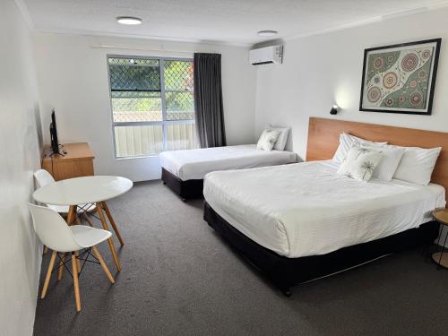a hotel room with two beds and a table at Nambour Heights Motel in Nambour