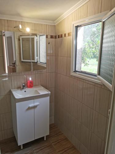 a bathroom with a white sink and a window at Harmony beach house in Roda