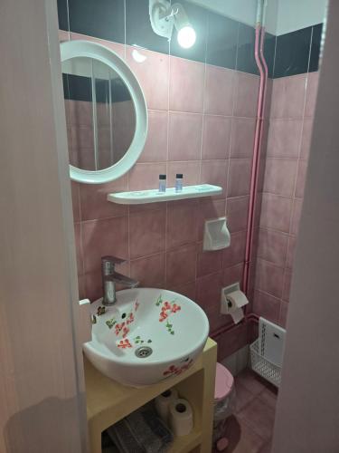 a bathroom with a sink and a mirror at Tony's Rooms in Alinda