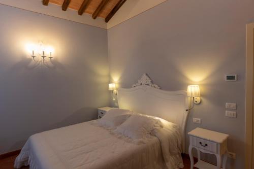a bedroom with a white bed and two night stands at Tenuta Piroddi in Montemurlo