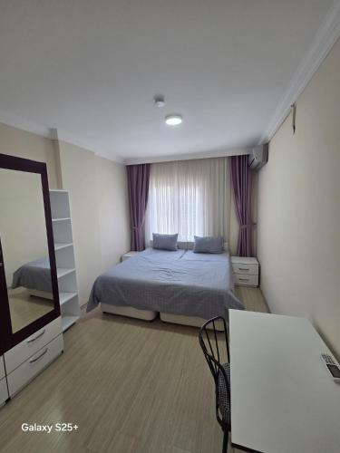 a bedroom with a bed and a television in it at Şahinler Suit Apart in Trabzon