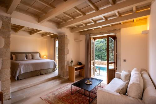a bedroom with a bed and a living room with a couch at Kapsaliana Village Hotel in Kapsalianá
