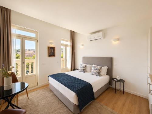 a hotel room with a bed and a table at Ribeira Porto by MyStay - Self Check-in Hotel in Porto