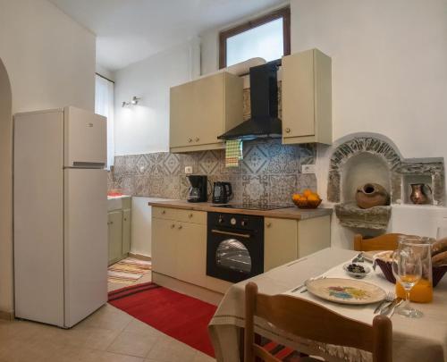 eine Küche mit einem Tisch und einem weißen Kühlschrank in der Unterkunft Feneri Traditional House Apt 1- 20' from Elafonisi beach in Elafonisi