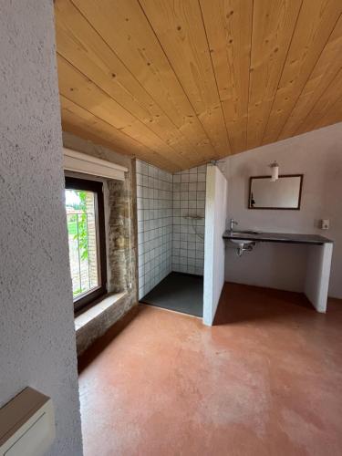 an empty room with a bathroom with a window at Ca La Botera in Verges
