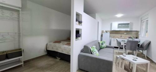 a living room with a couch and a dining room at Cherry Garden Apartment in Podgorica