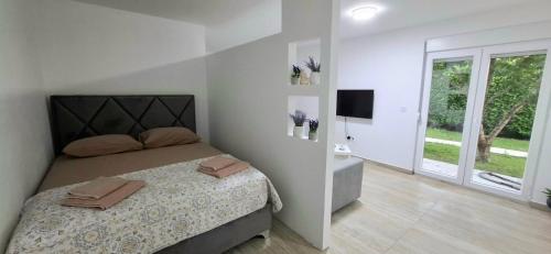 a bedroom with a bed and a television in it at Cherry Garden Apartment in Podgorica