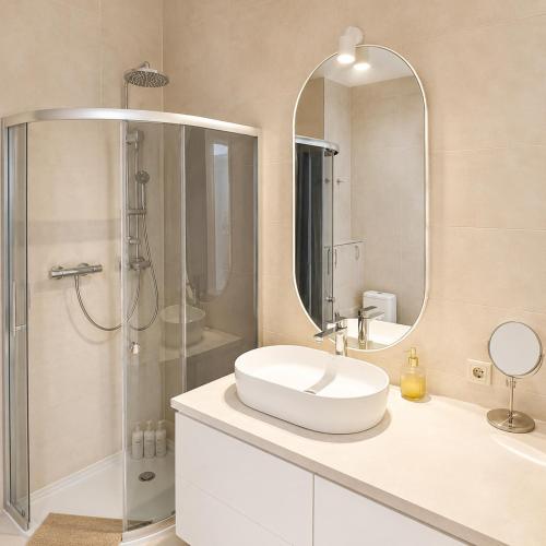 a bathroom with a sink and a shower and a mirror at Sun Shine 1 apartment in Liepāja