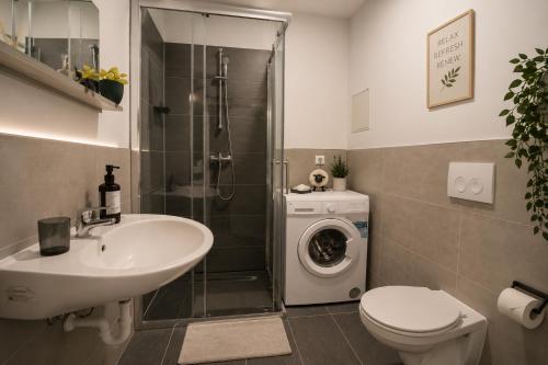 a bathroom with a sink and a washing machine at Prime Apartment Hotel in Nuremberg