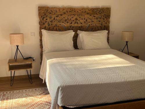 a bedroom with a large bed with a wooden headboard at Quinta de Barbêdo - Turismo Rural in Caniçada