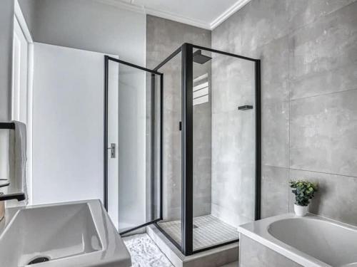 a bathroom with a shower and a tub and a sink at Royalty Suites in Chartwell Sandton in Chartwell