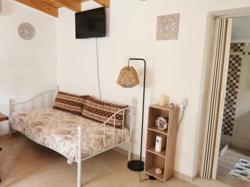 a bedroom with a bed and a tv on the wall at Harmony beach house in Roda