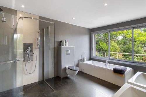 a bathroom with a tub and a shower and a sink at Villa Gecko avec piscine in Sari Solenzara