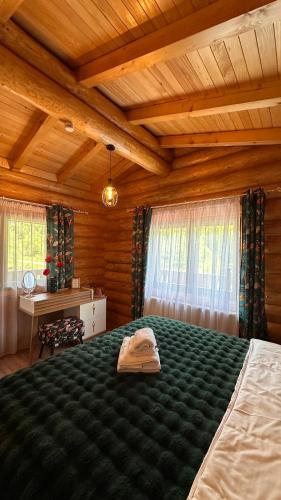 a bedroom with a bed with a hat on it at Casa Bucuriei - Plaiul Foii, Zărnești in Zărneşti