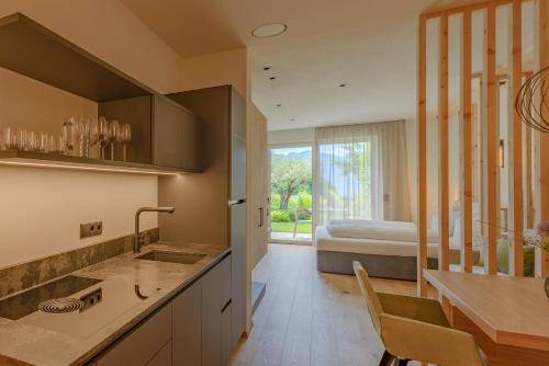 a kitchen with a sink and a room with a bed at Kardonighof Kaltern in Caldaro