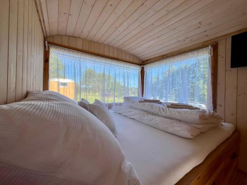 a room with four pillows on a bed with a window at Penzion Stanský Mlýn in Hlinsko