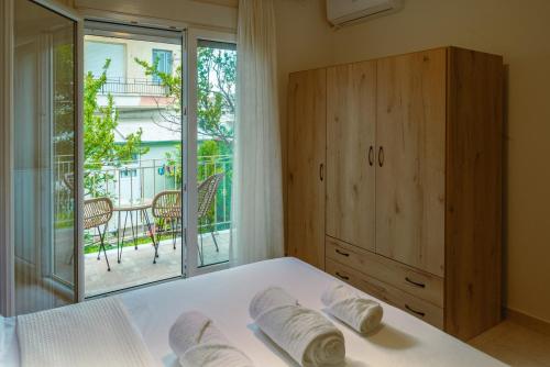 a bedroom with a bed and a window with a balcony at To Spiti in Keramoti