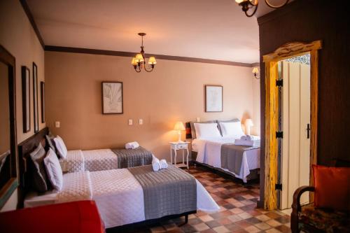 a hotel room with two beds and a mirror at Tiradentes Village in Tiradentes