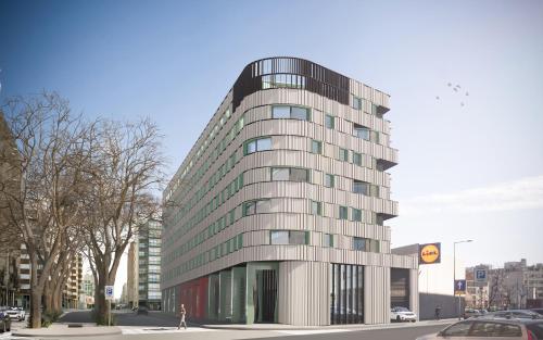a tall building with glass windows on a city street at Moov Hotel Matosinhos Sul in Matosinhos