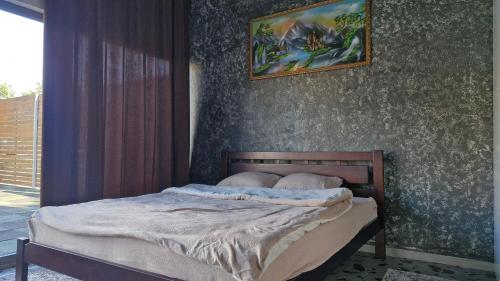 a bedroom with a bed with a picture on the wall at Villa Dacha in Izmail