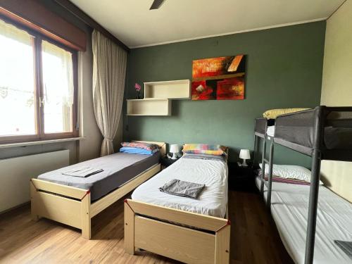two beds in a room with green walls at Villa Gianfranca - sentiti come a casa in Corno di Rosazzo