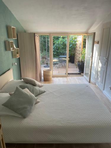 a large bed in a bedroom with a view of a patio at Les Robinsons in Sillans-la Cascade