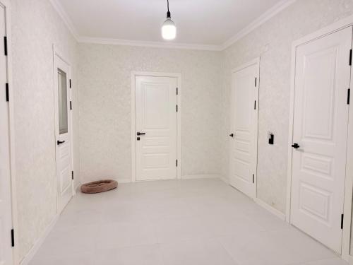 an empty room with white walls and white doors at Уютный дом GS in Kegeti