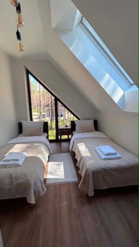 a attic room with three beds and a skylight at Roztoczańska Stodoła in Majdan Sopocki