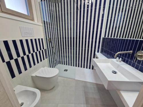 a bathroom with a toilet and a sink and a shower at Acqua Marina Rooms in La Caletta