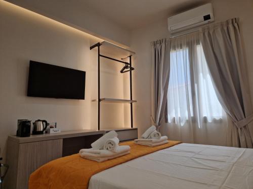 a hotel room with a bed with towels on it at Acqua Marina Rooms in La Caletta
