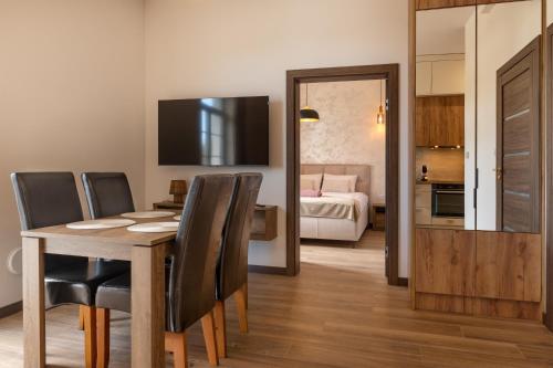 a dining room with a table and chairs and a bedroom at Rezydencja De Rosse in Jastrzębia Góra