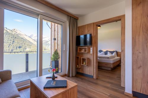 a living room with a bed and a large window at Gasthof Bergblick in Berwang