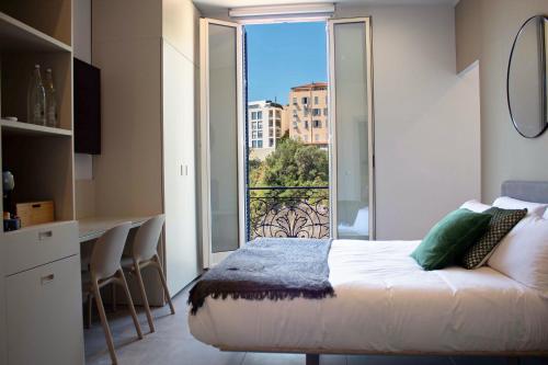 a bedroom with a bed and a large window at My Residence d'Azur in Beausoleil