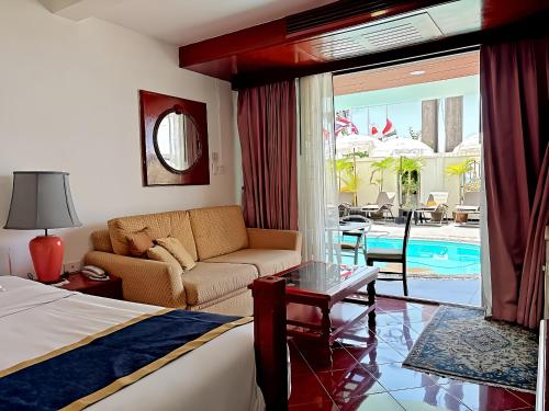 a hotel room with a bed and a couch and a table at Orchid Hotel and Spa Kalim Bay in Patong Beach