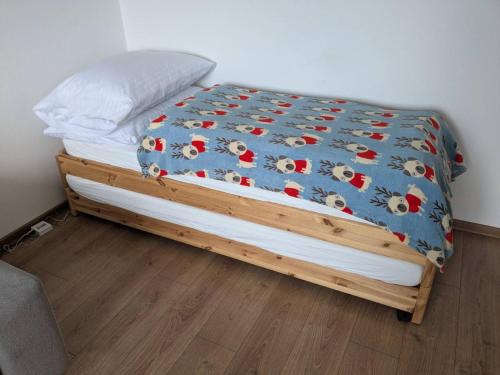 a bed with a blue comforter with chickens on it at Summit Suite in Vysoké Tatry