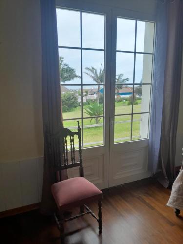 a chair sitting in front of a window with a door at Quinta do Sossego in Pico da Pedra