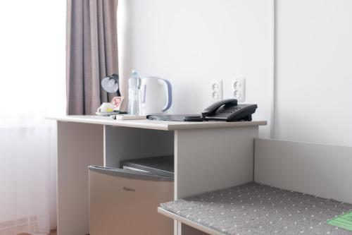 a white table with a coffee maker on top of it at Aktobe Hotel in Aktobe