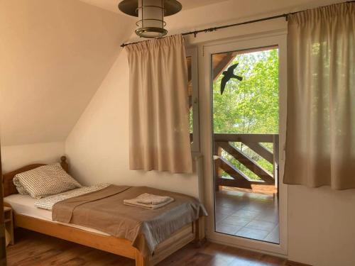 a bedroom with a bed and a large window at La Perla Villa del Lago in Paloznak