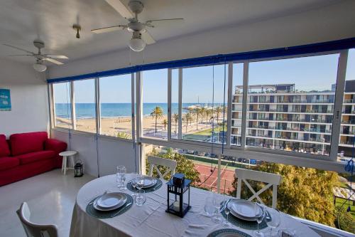 a dining room with a table and a view of the beach at Beachfront Apartment with Sea Views & Pool - El Puig in El Puig