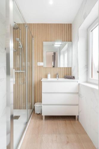 a bathroom with a white sink and a shower at Apartamento La Salamandra in Arriondas