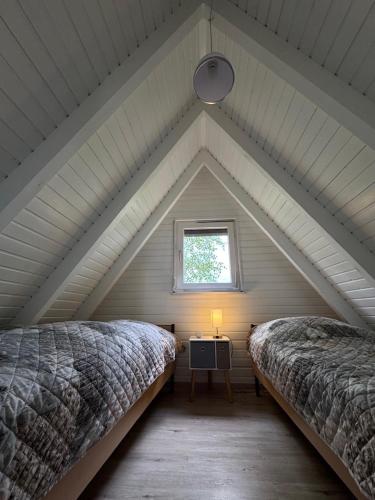 a attic bedroom with two beds and a window at Ferienhaus Conneforde in Wiefelstede